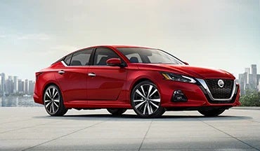 2023 Nissan Altima in red with city in background illustrating last year's 2022 model in Empire Nissan of Hillside in Hillside NJ