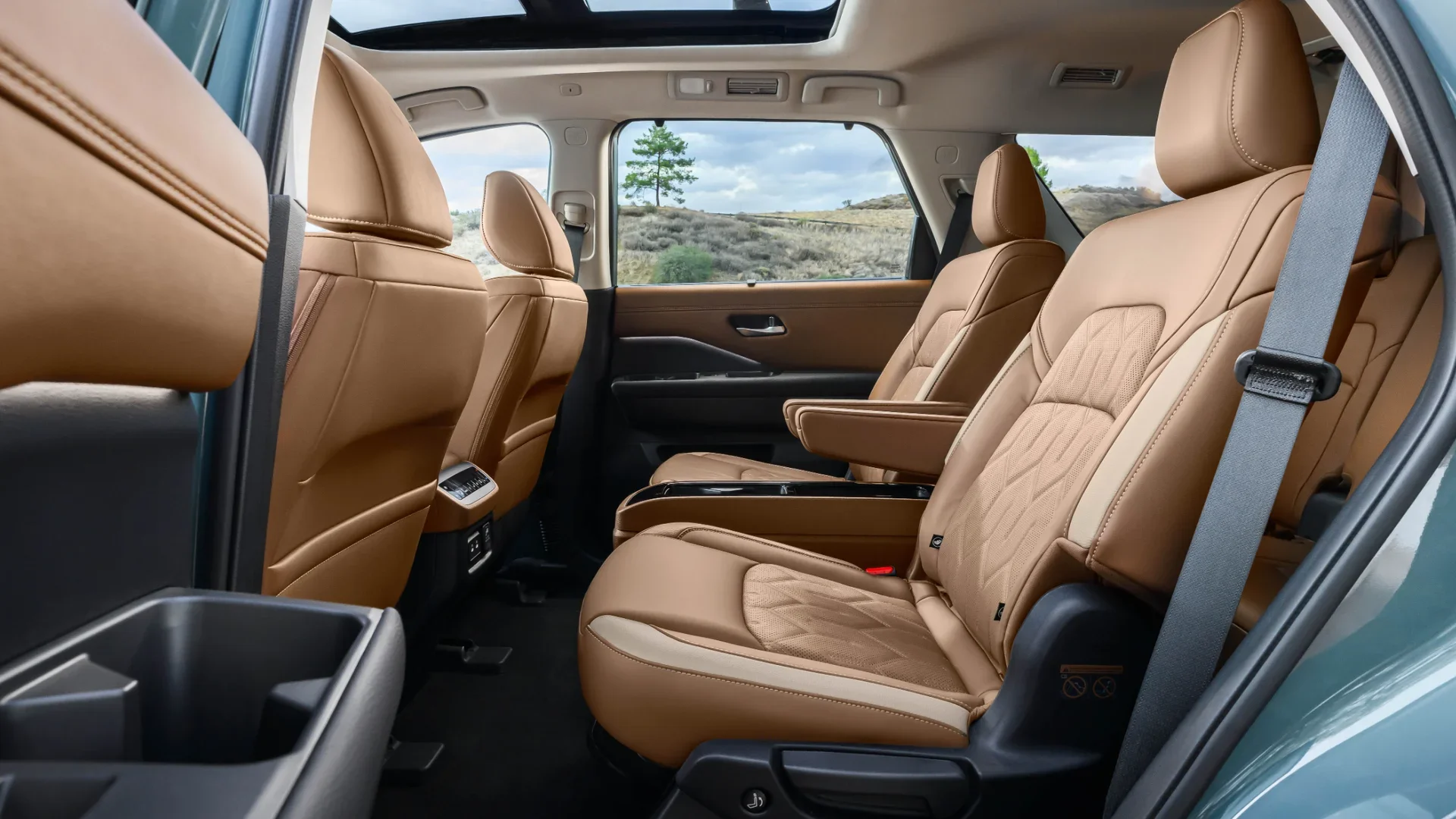2026 Nissan Pathfinder® second-row captain chairs in brown leather below a panoramic glass moonroof.